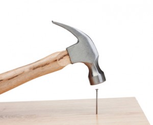 Hammer hitting a nail into a wood